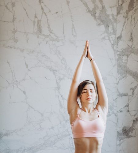 Woman practicing a calm yoga pose in a modern office space.